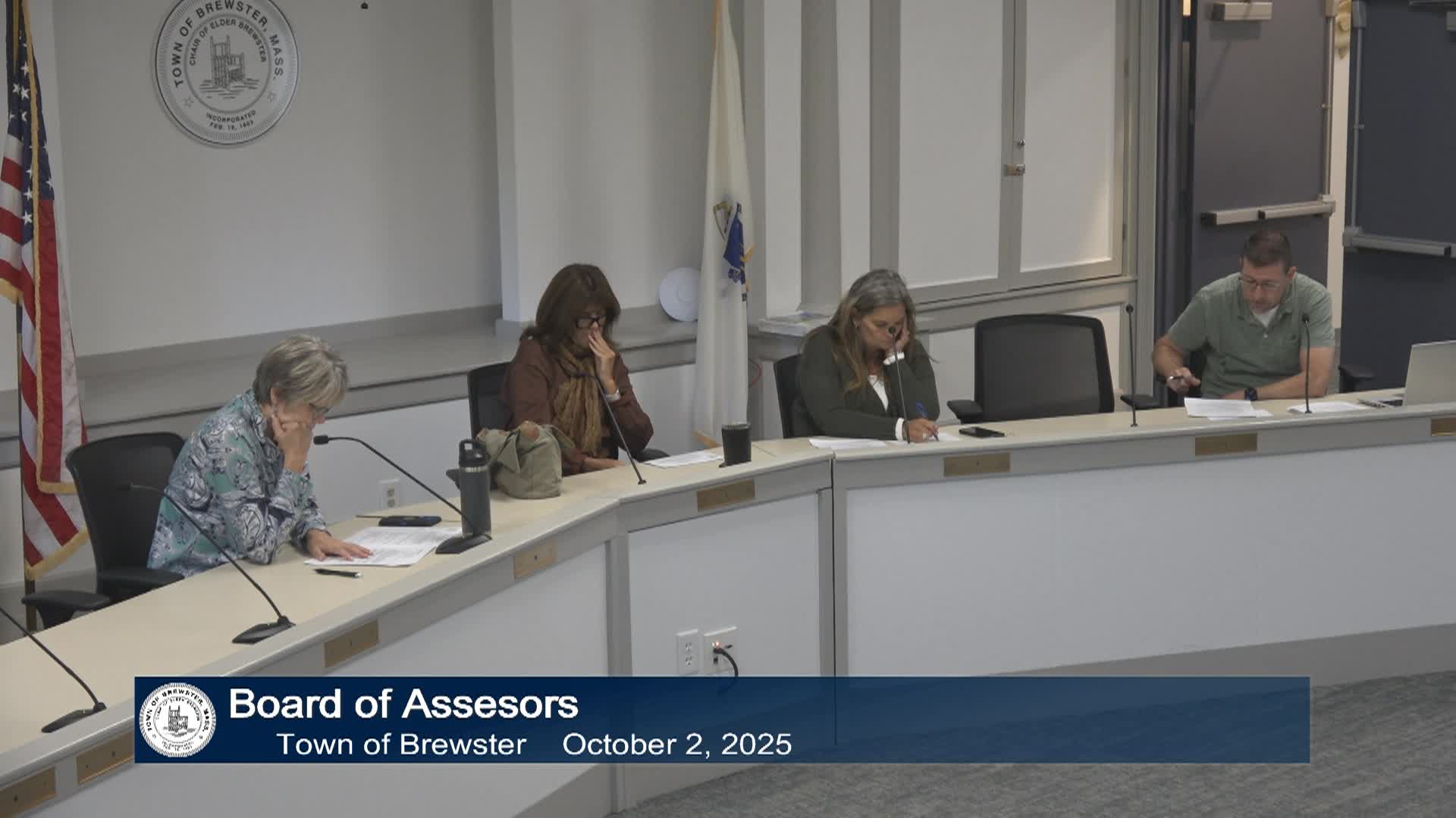 Three committee members and a staff person sit behind the dias in room A for their meeting.