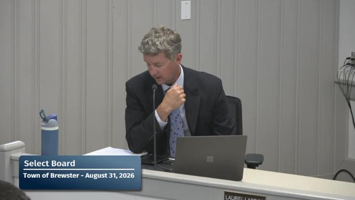 the town manager is looking down at his notes during the meeting